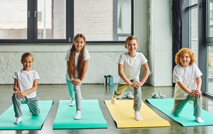 Kids doing yoga with smiling faces during online yoga classes for kids